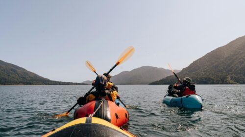 Two People Packrafting on a Scenic Mountain Lake Desktop Wallpaper