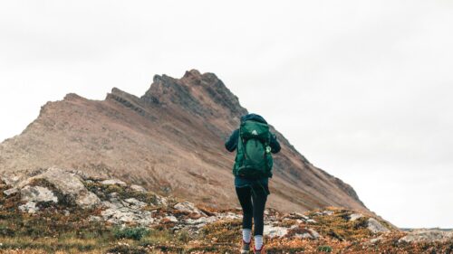 Hiker Trekking Through Rugged Mountain Landscape 4K Wallpaper