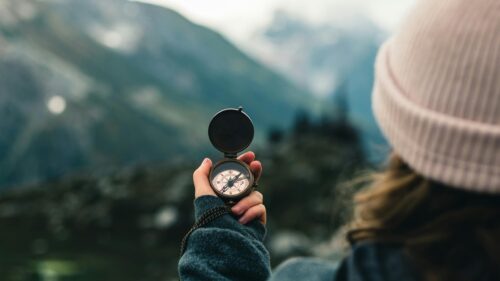 Person Holding Vintage Compass in Mountain Landscape Desktop Wallpaper