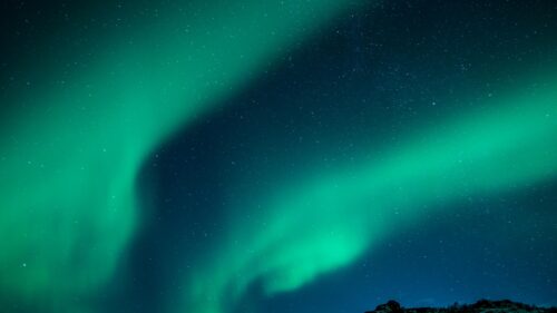 Vibrant Green Aurora Borealis Over Snowy Landscape 4K Wallpaper