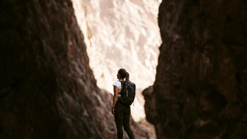 Woman Hiker Standing in Deep Desert Canyon 4K Wallpaper