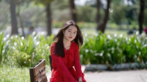 Asian Girl in Red Polka Dot Dress Sitting on Park Bench 4K Wallpaper
