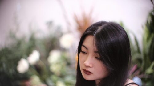 Sad Asian Girl with Brown Lipstick in Blurred Garden 4K Wallpaper