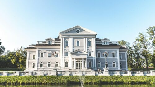 Stately Grey Mansion Architecture with Pond and Garden Desktop Wallpaper