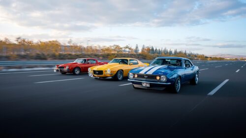 Three Classic Chevrolet Muscle Cars Driving on Highway 4K Wallpaper