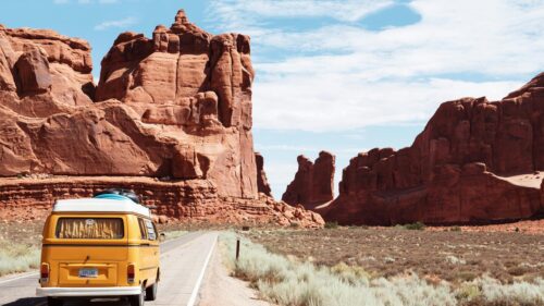 Yellow Vintage Camper Van on Desert Road Red Rocks 4K Wallpaper