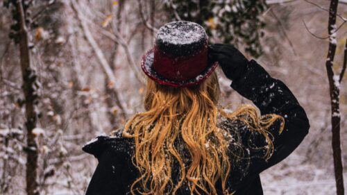 Woman with Red Hair and Top Hat in Snowy Forest 4K Desktop Wallpaper