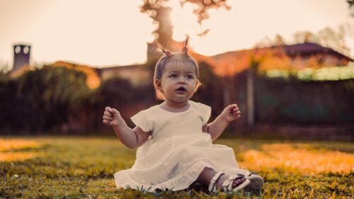 Cute Baby Girl in White Dress Sitting on Grass Desktop Wallpaper