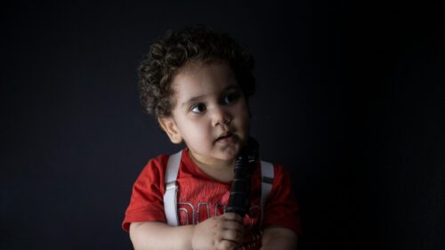 Cute Curly Haired Toddler in Red T-Shirt and Suspenders Desktop Wallpaper