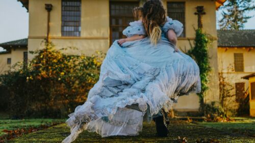 Woman Running in Vintage Blue Ball Gown Near Old Mansion Desktop Wallpaper