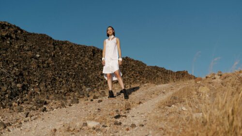 Fashion Model in White Dress Standing on Rocky Desert Trail Desktop Wallpaper