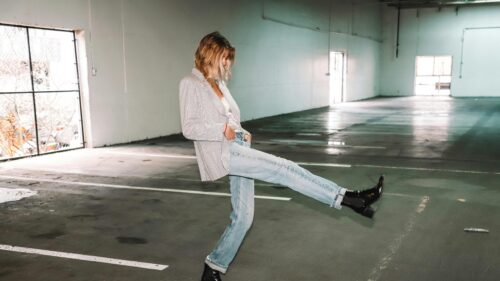 Stylish Woman Posing in Plaid Blazer and Jeans Desktop Wallpaper
