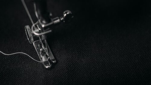 Macro Close-up of Sewing Machine Needle on Black Fabric Desktop Wallpaper