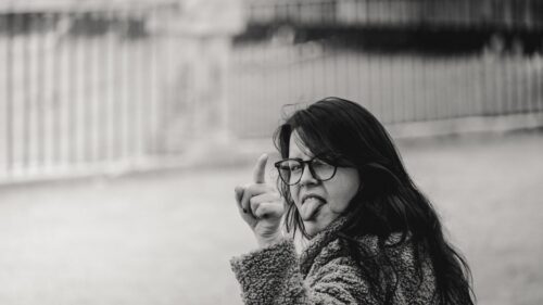 Playful Young Woman Sticking Tongue Out Black and White Desktop Wallpaper