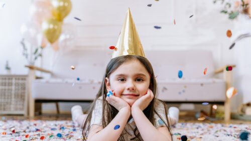 Adorable Happy Girl Wearing Party Hat with Colorful Confetti Desktop Wallpaper