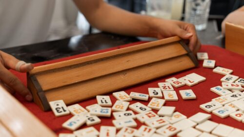 Close-up of Rummikub Game Tiles on Red Felt Table Desktop Wallpaper