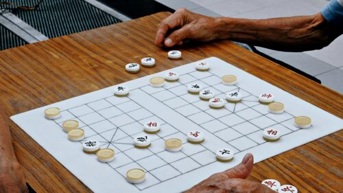 Elderly Hands Playing Traditional Chinese Chess Strategy Game 4K Wallpaper