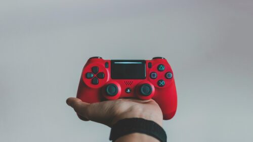 Red PlayStation DualShock Controller Held in Hand 4K Wallpaper