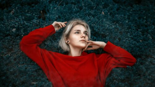 Stunning Blonde Girl in Red Sweater Resting in Nature 4K Wallpaper