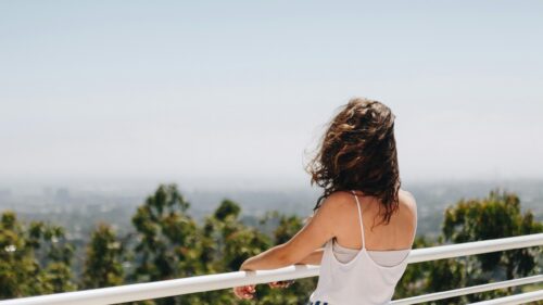 Woman Looking at City View from Hilltop 4K Desktop Wallpaper