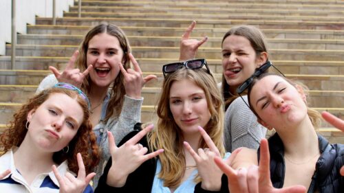 Group of Friends Making Rock Signs on Stairs Desktop Wallpaper