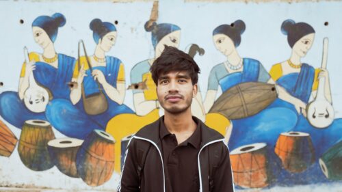 Young Man Standing Before Traditional Indian Musical Art Desktop Wallpaper