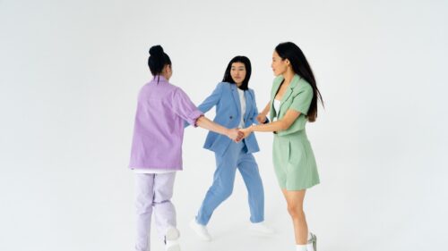 Three Women in Colorful Pastel Suits Holding Hands Desktop Wallpaper