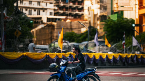 Lone Motorcyclist Riding Through Bangkok Streets 4K Wallpaper