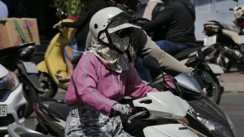 Motorcyclists Wearing Sun Protection Gear on Busy Street Desktop Wallpaper