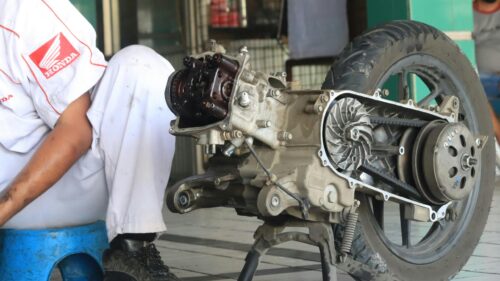 Mechanic Working on Scooter Engine Parts 4K Wallpaper
