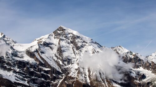 Majestic Snow Capped Mountain Peak Under Blue Sky 4K Wallpaper