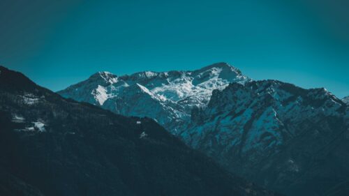 Majestic Snowy Peaks Under Clear Blue Sky Desktop Wallpaper