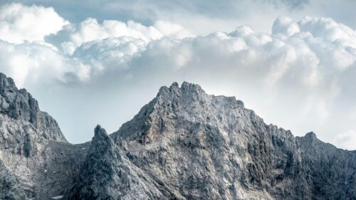 Majestic Rugged Mountain Peak Under Cloudy Sky 4K Desktop Wallpaper