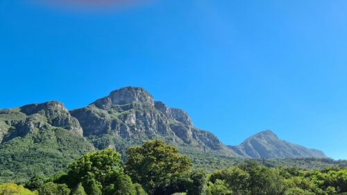 Majestic Mountain Range Under Clear Blue Sky 4K Wallpaper
