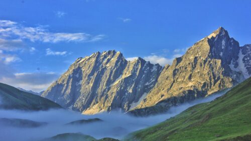 Majestic Snow Capped Mountain Peaks Above Valley Clouds 4K Desktop Wallpaper