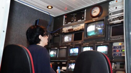 Woman Monitoring Television Production Inside Mobile Broadcast Control Room Desktop Wallpaper
