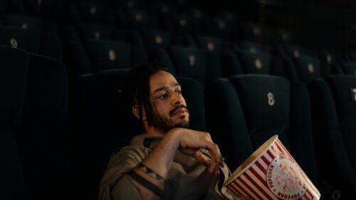 Young Man Watching Movie in Empty Cinema Theater 4K Wallpaper