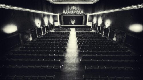 Eerie Abandoned Theater with Cinematic Face Screen Desktop Wallpaper