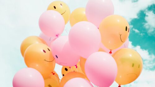 Happy Smiley Face and Pastel Balloons Against Blue Sky 4K Wallpaper