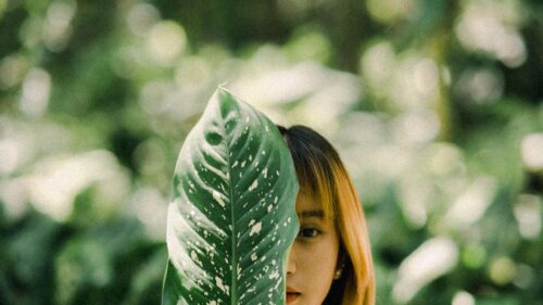 Mysterious Woman Behind Tropical Leaf Artistic Nature 4K Wallpaper