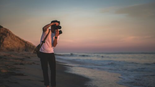 Photographer Capturing Golden Hour Sunset on Beach 4K Wallpaper
