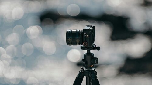 Professional Camera on Tripod Against Bokeh Water Surface 4K Wallpaper