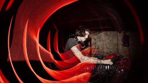 DJ Performing with Red Light Trails Music Desktop Wallpaper