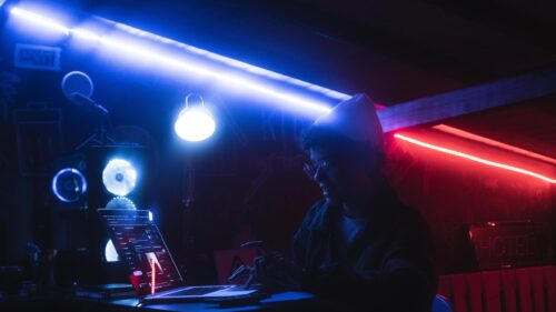 Cyberpunk Hacker Working on Laptop in Neon Light 4K Wallpaper