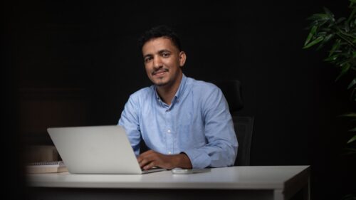 Professional Young Man Working on Laptop at Night 4K Wallpaper
