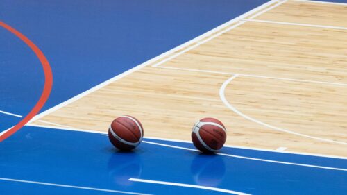 Two Molten Basketballs on a Professional Blue and Wood Court 4K Wallpaper