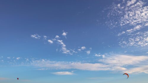 Minimalist Blue Sky with Kites Flying in Sunlight 4K Wallpaper
