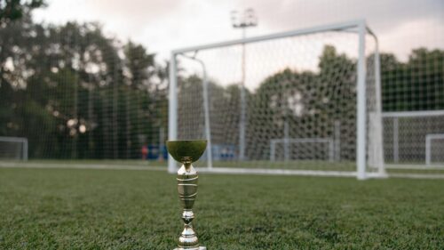 Championship Soccer Trophy on Green Grass Field 4K Wallpaper