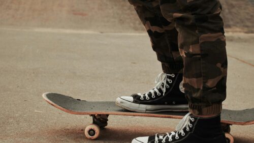 Skater Wearing Camo Pants and Black High Top Sneakers 4K Wallpaper