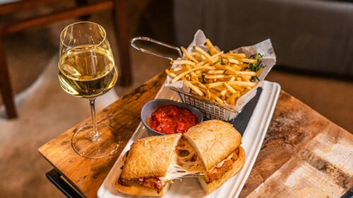 Gourmet Chicken Parmesan Sandwich with French Fries and White Wine 4K Wallpaper
